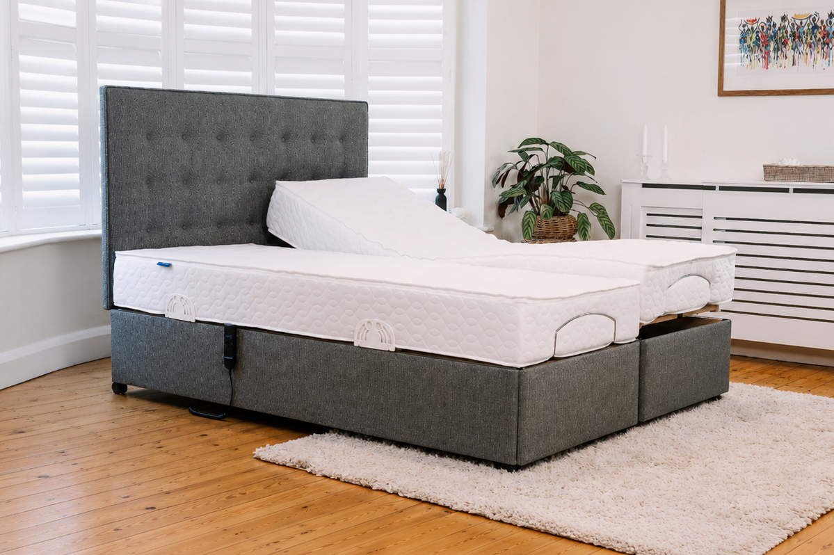Twin Majestic adjustable bed with grey upholstered base, buttoned headboard and one mattress raised at the head.