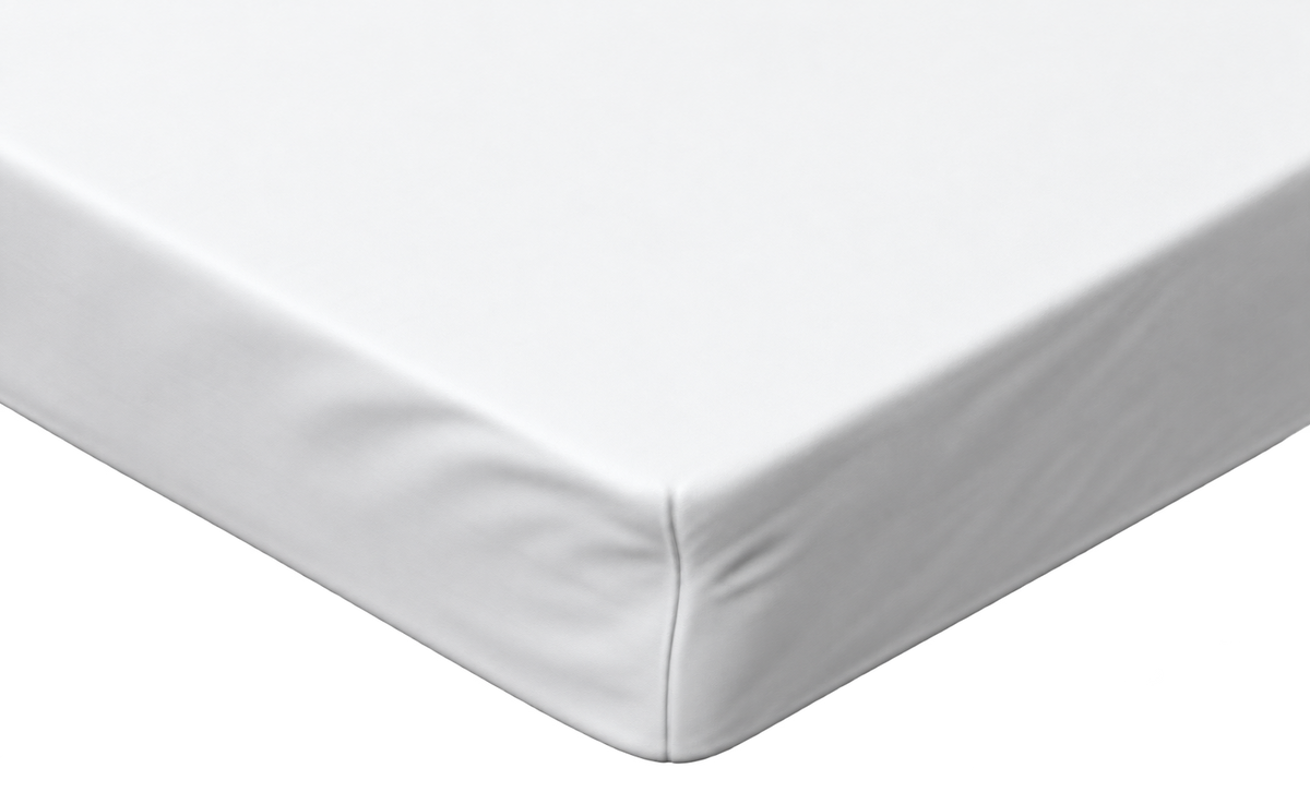A close-up of a white fitted sheet covering the corner of a mattress, showing the clean fabric and stitched edge against a white background.