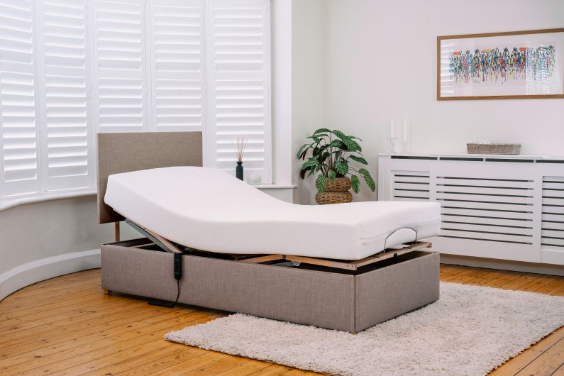 brown adjustable bed in a basic bedroom setting 