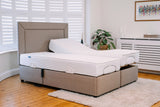 Beige adjustable bed in a room with wooden flooring and a plant.